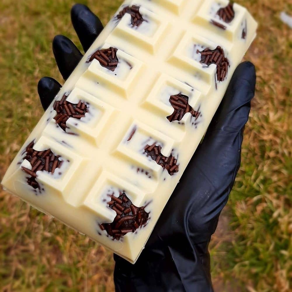 Barra de chocolate branco com porções de brigadeiro e granulado sobre cada quadrado